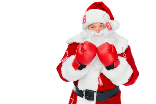 Серйозний Санта Клаус в боксерських рукавичках і червоному костюмі з тегами продажу ізольовані на білому — стокове фото