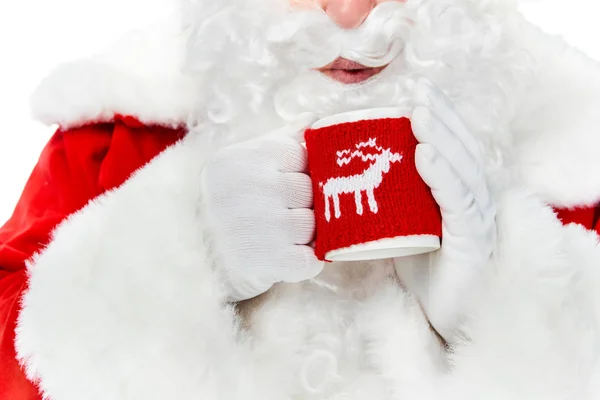 Cropped view of santa claus with white beard blowing on hot drink in cup isolated on white — Stock Photo