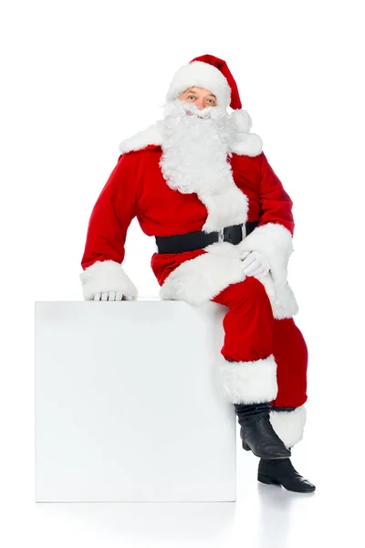 Santa claus sitting on white empty cube with copy space isolated on white — Stock Photo