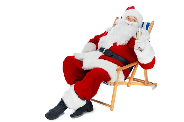 Santa claus descansando na cadeira de praia com copo de champanhe isolado no branco — Fotografia de Stock