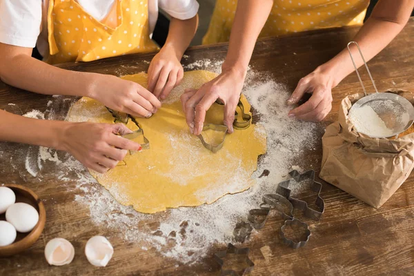 Частковий вид на дитину з матір'ю і бабусею, що готує печиво разом на кухні — стокове фото