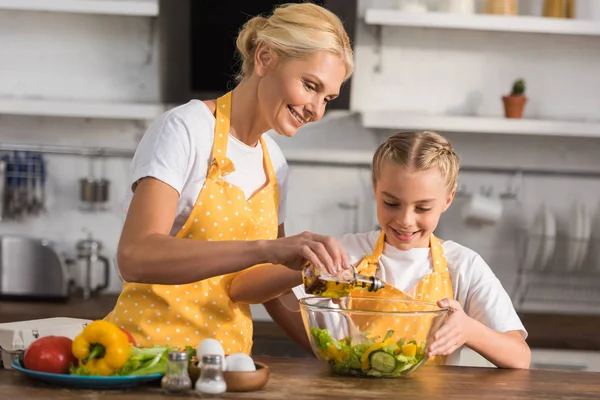 Feliz abuela y nieta en delantales cocinar juntos - foto de stock