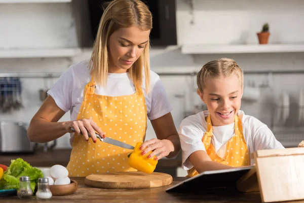 Beautiful happy mother and daughter cooking together in kitchen — Stock Photo