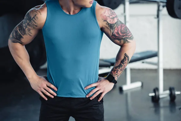 Cropped view of young tattooed sportsman at gym — Stock Photo