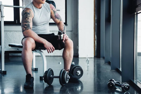 Vista parziale del giovane sportivo che si allena con i manubri in palestra — Foto stock