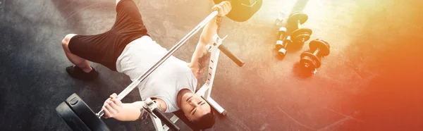 Muskulöser Sportler beim Training mit der Langhantel im Fitnessstudio im Sonnenlicht — Stockfoto