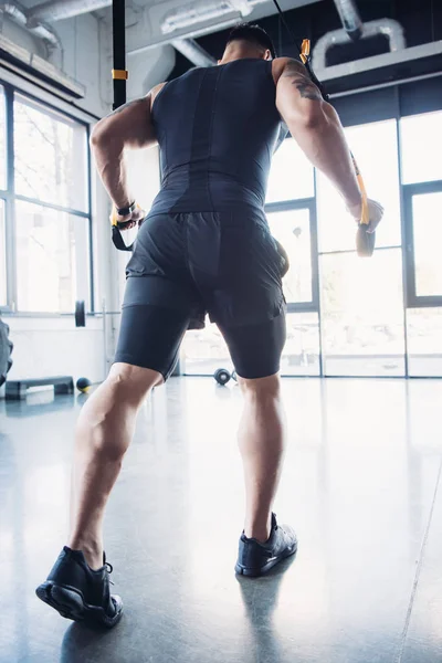 Молодий м'язистий спортсмен тренування з смугами опору в тренажерному залі — стокове фото