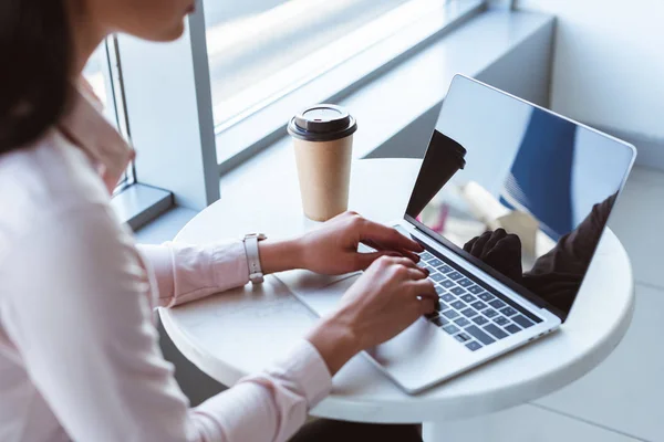Nahaufnahme einer jungen Geschäftsfrau, die am Flughafen Kaffee trinkt und am Laptop tippt — Stockfoto