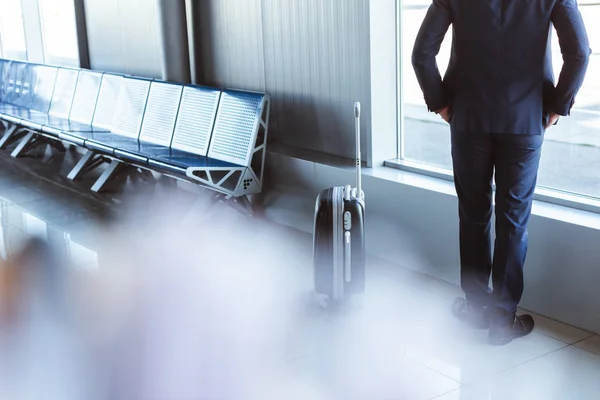 Обратно вид бизнесмена, стоящего в зале вылета в аэропорту — стоковое фото