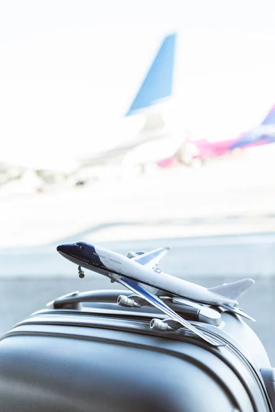 Крупным планом модели самолета на сером чемодане в аэропорту — стоковое фото