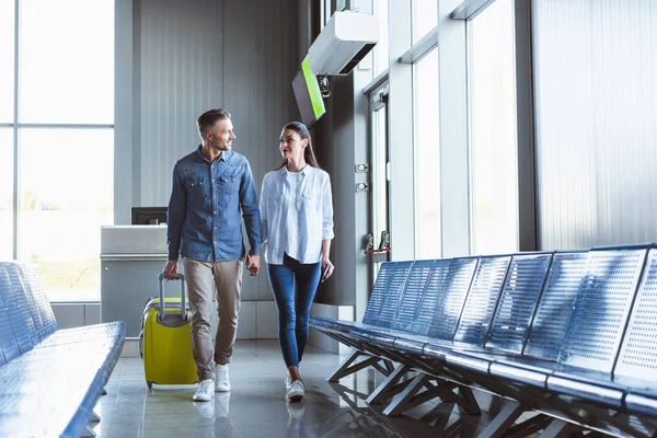 Hermosos turistas mirándose en movimiento en el aeropuerto - foto de stock