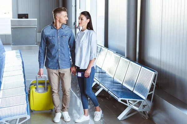 Hombre y mujer mirándose antes del viaje en el aeropuerto - foto de stock