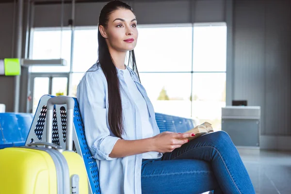 Brunette woman with book sitting in the airport — Stock Photo