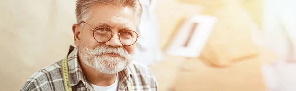 Porträt eines glücklichen reifen Handwerkers mit Brille, der im Atelier in die Kamera blickt — Stockfoto