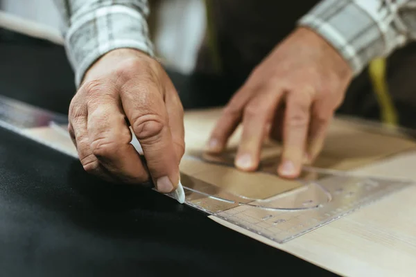 Geschnittenes Bild eines Handtaschenhandwerkers, der in der Werkstatt Maße auf Leder anfertigt — Stockfoto