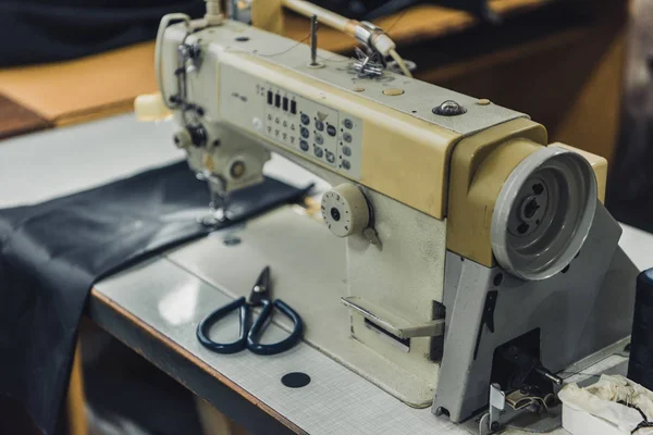 Enfoque selectivo del lugar de trabajo a medida con máquina de coser en el taller - foto de stock