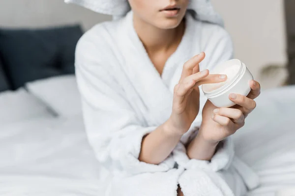 Vista cortada da mulher com creme cosmético em recipiente de plástico — Fotografia de Stock
