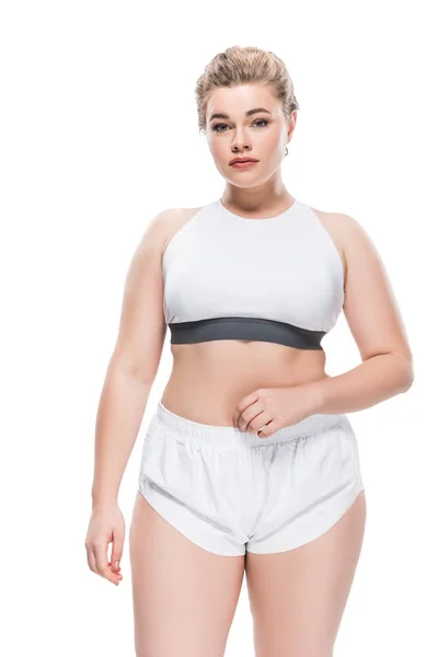 Attractive overweight girl in sportswear looking at camera isolated on white — Stock Photo