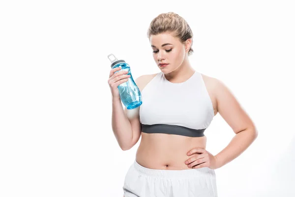 Chica de gran tamaño en ropa deportiva celebración botella de agua aislada en blanco — Stock Photo