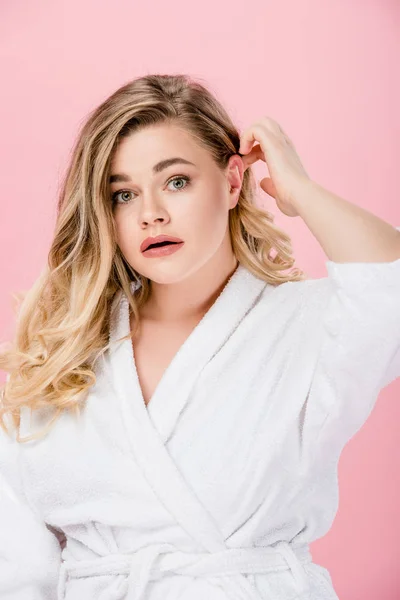 Portrait de jeune femme surdimensionnée choquée en peignoir regardant la caméra isolée sur rose — Photo de stock