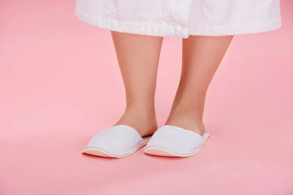 Cropped shot of young overweight woman in white slippers and bathrobe standing on pink — Stock Photo