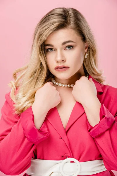 Beautiful young woman in pink trench coat looking at camera isolated on pink — Stock Photo