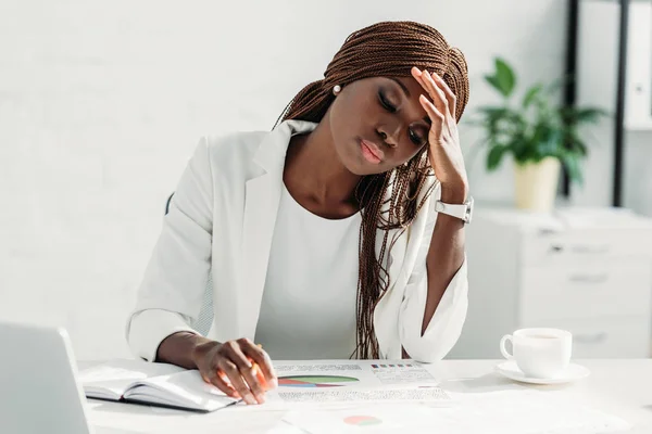 Cansada mulher de negócios adulta afro-americana sentada na mesa e trabalhando no projeto no escritório — Fotografia de Stock