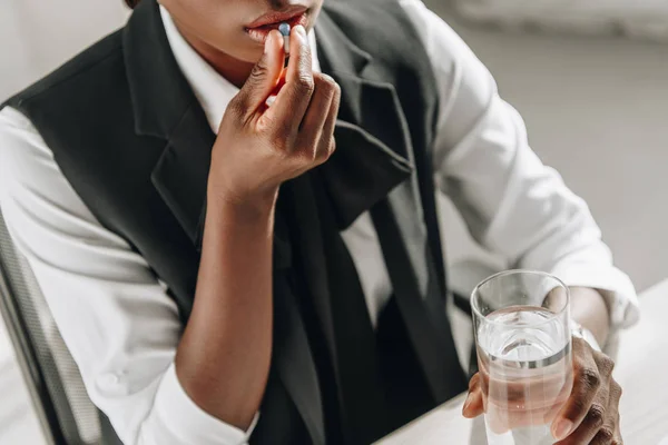 Cropped view of african american adult businesswoman taking flu medication — Stock Photo