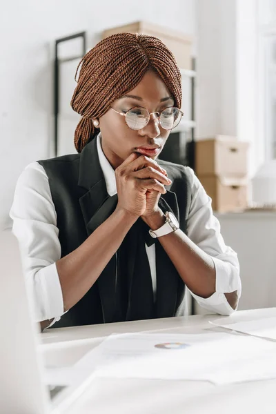 Pensativo afro-americano feminino adulto arquiteto em óculos trabalhando em documentos no escritório — Fotografia de Stock