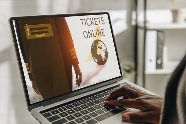 Ausgeschnittene Ansicht eines afrikanisch-amerikanischen Geschäftsmannes mittels Laptop mit Online-Ticketwebseite auf dem Bildschirm — Stockfoto