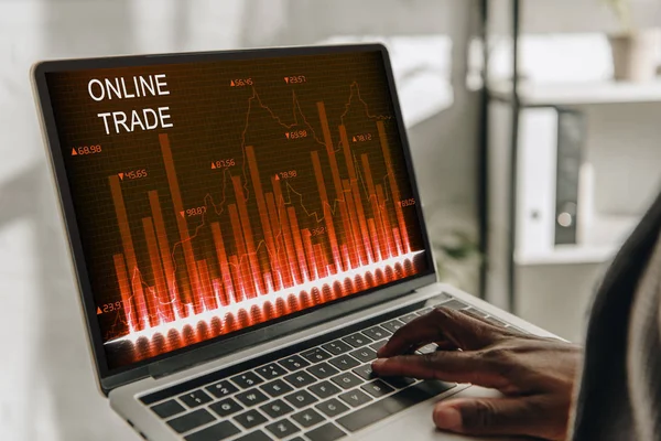 Cropped view of african american businessperson using laptop with online trades on screen — Stock Photo