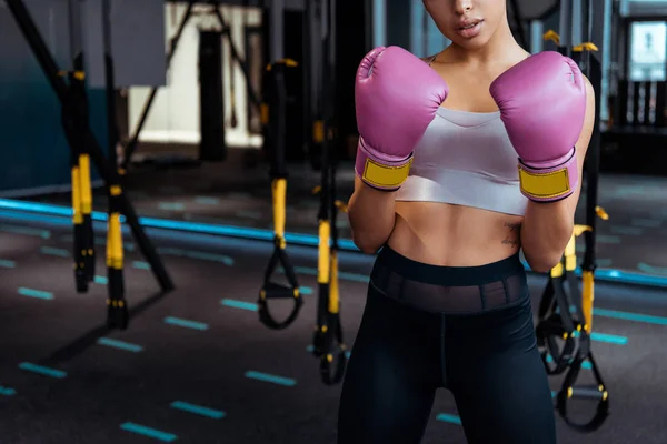 Partial view of  female boxer in pink boxing  gloves practicing boxing in gym — Stock Photo