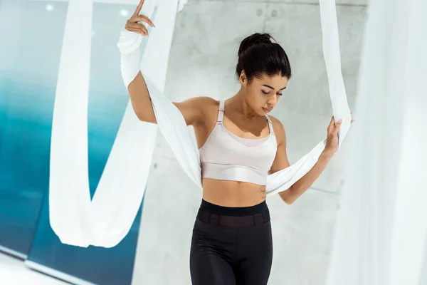 Bella ragazza sportiva che pratica yoga in amaca in studio — Foto stock