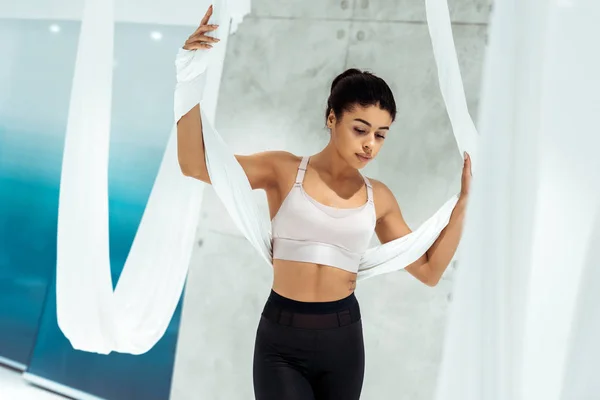 Attrayant sportive fille pratiquant le yoga dans un hamac en studio — Photo de stock