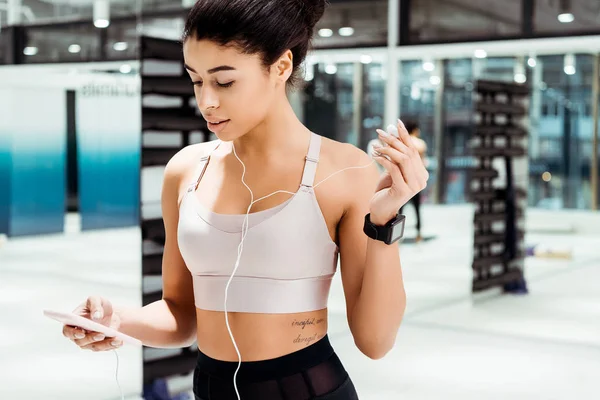 Wunderbare sportliche Mädchen hören Musik in Fitnessstudio — Stockfoto