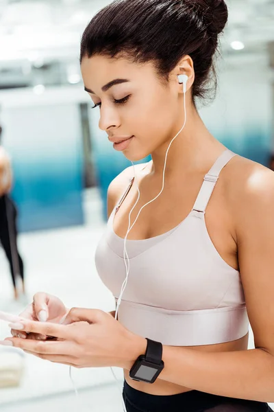 Attraktive sportliche Mädchen hören Musik in Fitnessstudio — Stockfoto