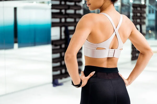 Back cropped view of girl in sportswear in fitness gym — Stock Photo