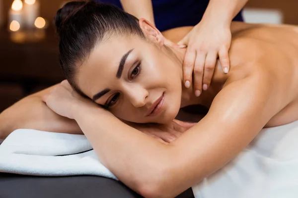 Hermosa sonriente joven mujer teniendo masaje en spa — Stock Photo