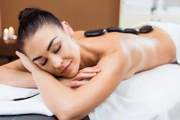 Schöne lächelnde Mädchen genießen Hot Stone Massage im Wellness-Salon — Stockfoto