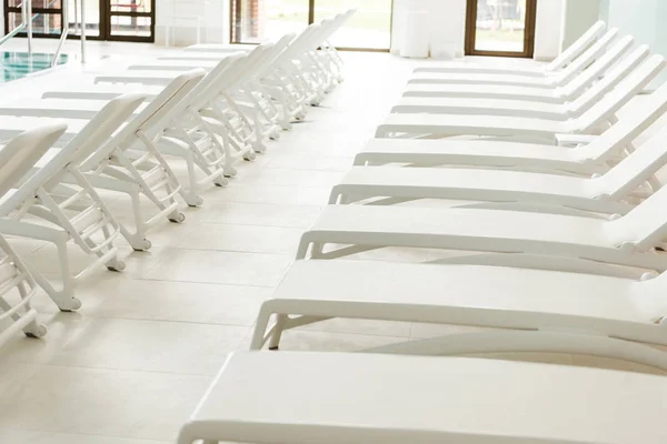 Chaises longues blanches vides près de la piscine dans le centre spa — Photo de stock