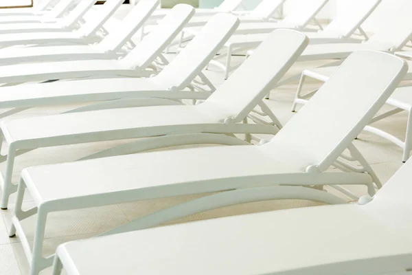 Empty white sunbeds in modern spa center — Stock Photo