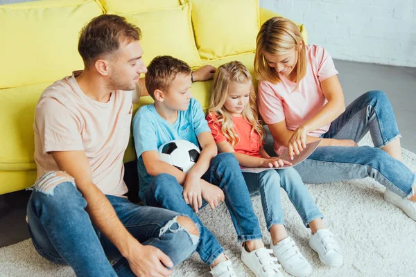 Щаслива сім'я сидить і читає книгу разом — стокове фото