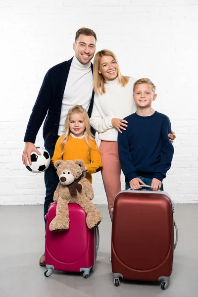 Happy family with luggage ready to go on winter holidays — Stock Photo