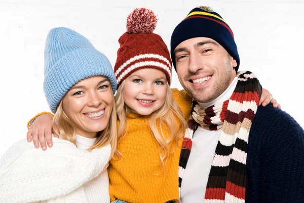 Family portrait of parents and daughter in winter clothes looking at camera isolated on white — Stock Photo