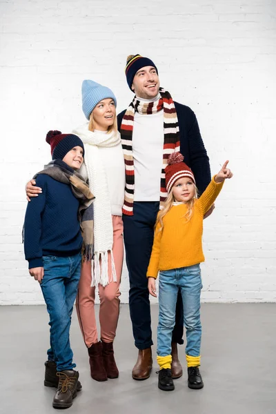 Familia sonriente en ropa casual mirando hacia otro lado sobre fondo blanco - foto de stock