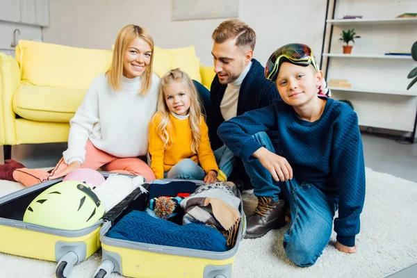 Familia feliz pasar un buen rato y embalaje para las vacaciones de invierno, concepto de viaje - foto de stock