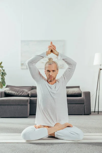 Mann meditiert in Lotusposition mit Mudra-Zeichen und blickt in die Kamera — Stockfoto