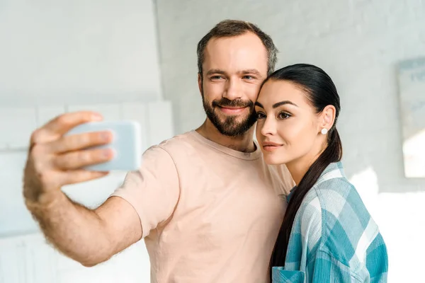 Hermosa feliz pareja tomando selfie en smartphone - foto de stock