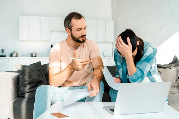 Marido e mulher usando laptop e tendo problemas financeiros em casa — Fotografia de Stock
