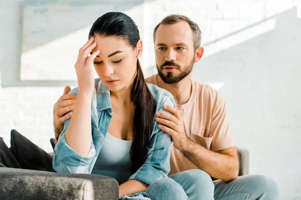 Uomo abbracciando e cercando di consolare moglie depressa dopo aver discusso — Foto stock